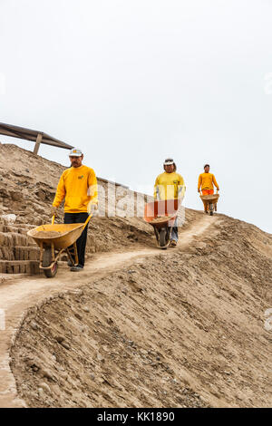 Trois ouvriers péruviens locaux avec des brouettes de travailler sur la restauration de la ruines pré-Inca à Huaca Pucllana ou Huaca Juliana, Miraflores, Lima, Pérou Banque D'Images