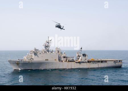 Un MH-60 de la marine américaine hélicoptère Seahawk vole au-dessus de la marine américaine de classe Harpers Ferry landing ship dock amphibie USS Pearl Harbor lors de l'exercice alligator 8 septembre 2017 dague dans le golfe d'Aden. (Photo de la psc2) planetpix kristina jeunes via Banque D'Images