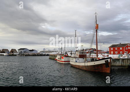 Bateaux de pêche -ancien et moderne, avec les coques en bois et métal- amarrés dans le port. hjells ou racks en bois pour sécher le poisson-monts de vestvagoya en arrière-plan Banque D'Images