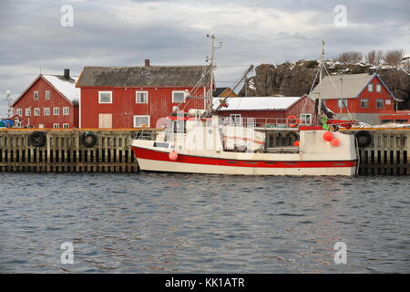 Bateau de pêche amarré dans le port de pêche traditionnel en bois-huttes ou rorbuer peints en rouge maintenant pour l'utilisation touristique-stangerholmen colline en arrière-plan. laukvik-v Banque D'Images