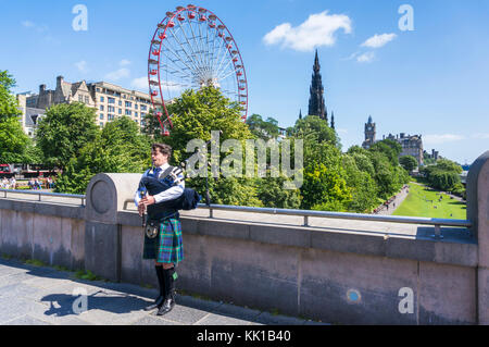 Edinburgh scotland Edinburgh Scottish piper jouant de la cornemuse devant les jardins de Princes street et du centre-ville d'édimbourg Royaume-Uni centre de roue Banque D'Images