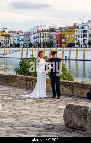 Une fiancée, et le marié en uniforme militaire qui pose pour les photographies de mariage, Guadalquivir, Séville, Andalousie, espagne. Banque D'Images