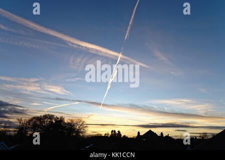 Sentiers d'aéronefs con au crépuscule dans la banlieue de Sky Angleterre UK Banque D'Images