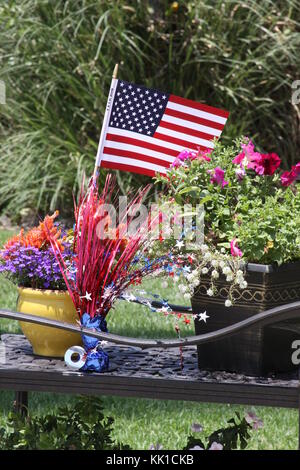 Un drapeau américain décore un pot de fleurs pour 4e de juillet. Banque D'Images