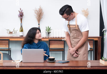 Le client se plaint d'Asie femme garçon à propos de la nourriture dans un café restaurant,service de l'émotion malheureuse in coffee shop Banque D'Images