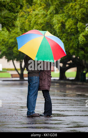 Close up image d'un couple amoureux permanent, sous un parapluie sous la pluie Banque D'Images