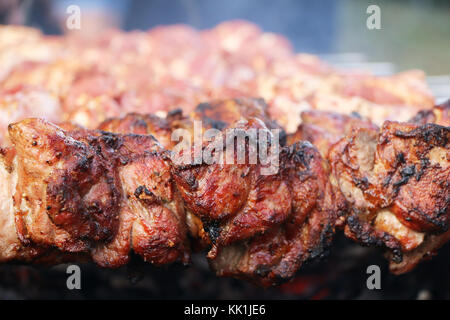 Rose cuit délicieux shish kebab viande sur barbecue Brochettes dans la fumée. La grille chaude nourriture Banque D'Images