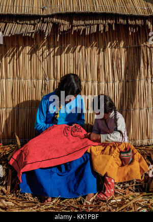 Les filles autochtones uro l'artisanat, les îles flottantes des Uros, lac Titicaca, région de Puno, Pérou Banque D'Images