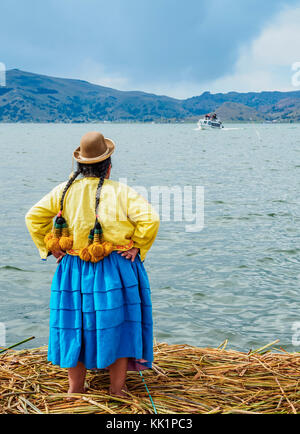 Les Uro Dame en attendant le bateau avec les touristes, les îles flottantes des Uros, Lac Titicaca, région de Puno, Pérou Banque D'Images