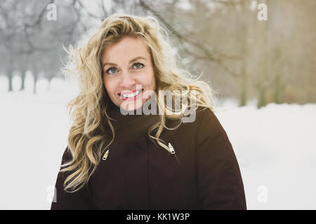 Woman enjoying a winter walk through snow covered park Banque D'Images