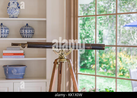 Télescope sur un trépied dans un salon d'East Hampton Banque D'Images