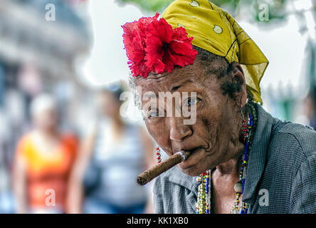 Une femme habillée excentriquement avec un cigare dans la bouche attend que les conseils soient photographiés par les touristes dans la vieille Havane, Cuba Banque D'Images