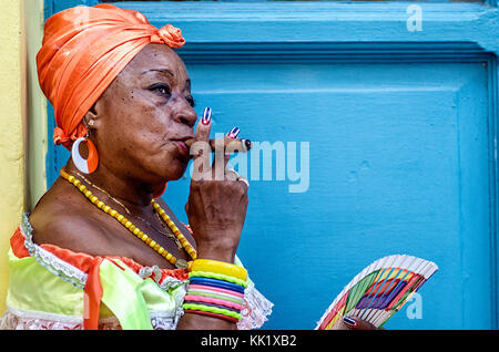 Une femme habillée excentriquement avec un cigare dans la bouche attend que les conseils soient photographiés par les touristes dans la vieille Havane, Cuba Banque D'Images