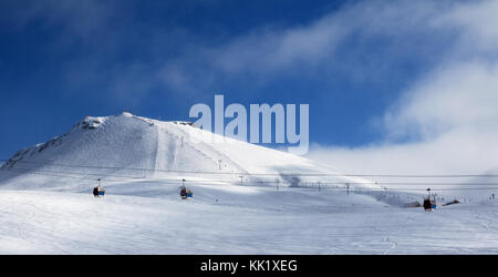 Vue panoramique de gondola et des télésièges sur station de ski de soirée d'hiver avec des chutes de neige. montagnes du Caucase, la Géorgie, la région gudauri. Banque D'Images