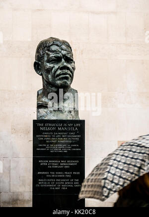 Nelson Mandela avec buste femme floue et parapluie marcher passé, Royal Festival Hall, South Bank, Londres, Angleterre, Royaume-Uni Banque D'Images