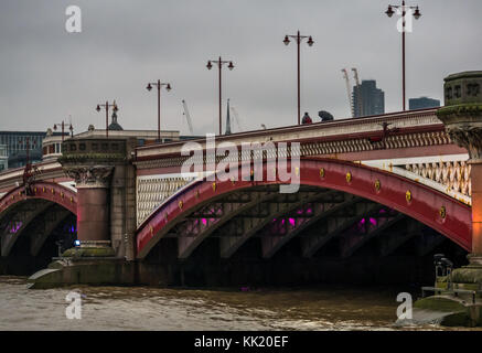 Vue sur les gens qui marchent sur Blackfriars Bridge sur la Tamise, avec des poteaux de lampes à l'ancienne, Londres, Angleterre, Royaume-Uni, le jour de pluie gris Banque D'Images