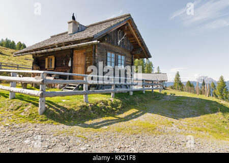 Berger en bois lodge sur un pâturage avec highland paysage de montagne alpin dans l'ouest de la Carinthie, Autriche. Banque D'Images