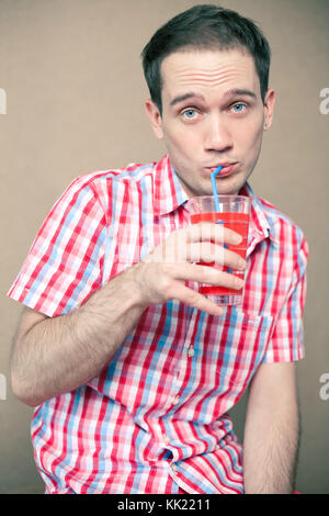 Confus des blue-eyed boy drinking hipster sur fond de bois Banque D'Images