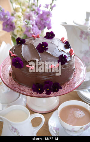 Gâteau au chocolat avec des fleurs et du thé l'après-midi. Le format Portrait. Banque D'Images