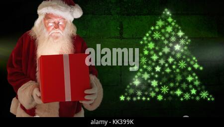 Digital composite de Santa holding gift et Snowflake Christmas Tree forme motif vert brillant Banque D'Images