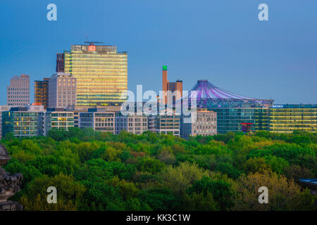 Berlin Mitte, vue au crépuscule à travers le Tiergarten vers bâtiments dans la région de Berlin Potsdam reflétant l'incandescence colorée d'un coucher de soleil. Banque D'Images