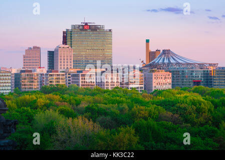 La ville de Berlin, à la tombée de la vue à travers le Tiergarten vers bâtiments dans la région de Berlin Potsdam reflétant l'incandescence colorée d'un coucher de soleil. Banque D'Images