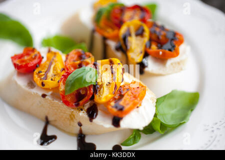 Bruschetta au fromage à la crème, la moitié des tomates séchées et basilic Banque D'Images