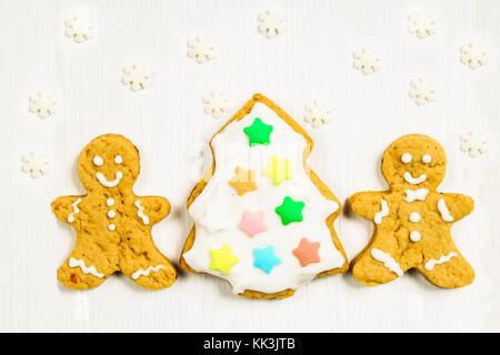 Gingerbread men amis de l'arbre de Noël sur une table en bois blanc Banque D'Images