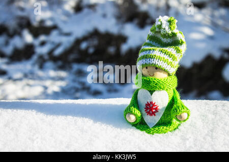 Fille en bois jouet dans un style scandinave en vert tricoté des vêtements dans la neige. jouets de Noël Banque D'Images