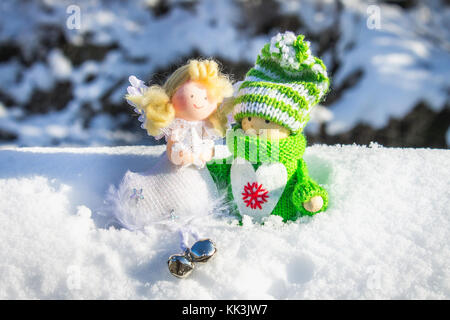 Fille en bois jouet dans un style scandinave de vêtements tricotés green sur la neige et angel jouets de Noël. Banque D'Images