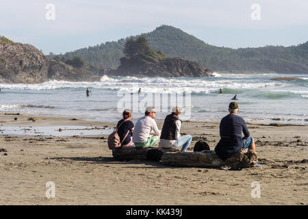 Plage Chesterman près de Tofino, C.-B., Canada (septembre 2017) - famille assise sur bois. Banque D'Images