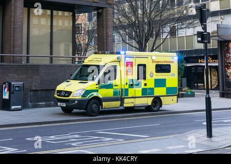 Une ambulance d'urgence de la London ambulance service garé avec feux bleus clignotant dans le centre de Croydon. Banque D'Images