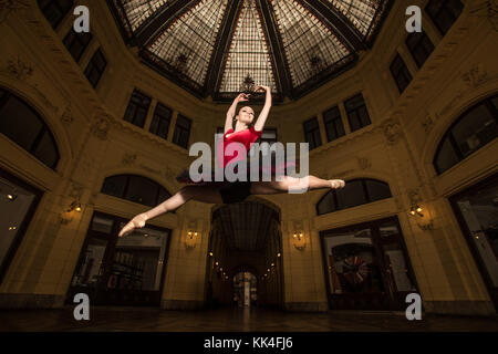 Ballerine Natalia Horsnell faire un split jump dans le couloir urbain public Oktogon à Zagreb, Croatie. Banque D'Images