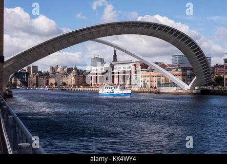 Un bateau de plaisance en-tête pour le millennium bridge, qui s'étend entre les deux quais de Newcastle upon Tyne et gateshead en Angleterre du Nord-Est Banque D'Images