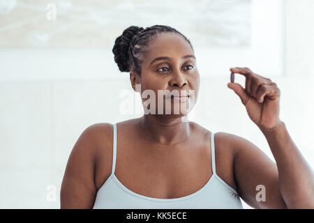 Hâte femme africaine à la recherche d'un comprimé dans sa main Banque D'Images