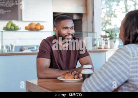Jeune homme africain apprécie sa date dans un café Banque D'Images