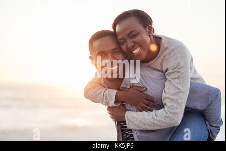 Smiling african couple bénéficiant d'une journée à la plage Banque D'Images