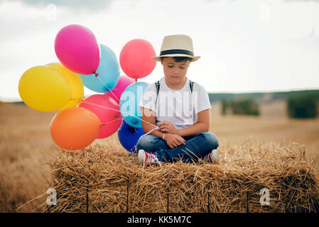 Enfant triste avec des ballons sur le terrain Banque D'Images