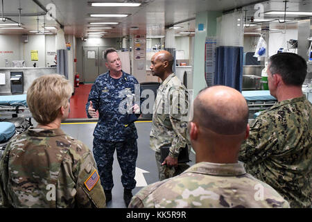 171110-N-Zn152-0061 SAN JUAN, Puerto Rico (nov. 10, 2017) Le Capitaine Kevin Buckley (deuxième à gauche), commandant de l'Armée de la commande de transport maritime navire-hôpital USNS Comfort'S (T-AH 20) installation de traitement médical traite les soins aux patients avec le brigadier. Le général Michael J. Talley (centre), du Commandement des forces de l'armée américaine, chirurgien au cours d'une visite en soulignant les capacités médicales du navire. Comfort est mouillée à côté de la jetée à San Juan, Puerto Rico, à fournir des secours humanitaires. Le ministère de la Défense soutient l'Agence fédérale de gestion des urgences, le principal organisme fédéral, en aidant les personnes touchées Banque D'Images