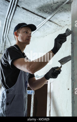 Homme obtient le plâtre pour fixer le guide pour aligner les murs dans l'avenir Banque D'Images