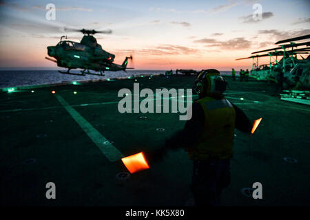 MER MÉDITERRANÉE (nov 6, 2017) Aviation Boatswain's Mate (Handling) 3rd Class Esmerelda Hernandez, de Corpus Christi, Texas, Et affecté au département de l’air à bord du navire de transport amphibie de classe San Antonio USS San Diego (LPD 22), dirige un Viper AH-1Z, attaché à l’escadron marin de Tiltrotor moyen (VMM) 161 (renforcé), sur le pont de vol du navire le 6 novembre 2017. San Diego est déployé avec le America Amphiobie Ready Group et la 15e unité expéditionnaire maritime pour soutenir la sécurité maritime et la coopération en matière de sécurité du théâtre dans le cadre des efforts déployés dans la zone de la 6e flotte des États-Unis Banque D'Images