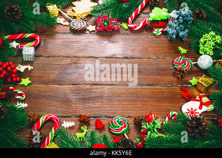 Cadre de Noël avec des branches d'arbre de Noël, ornements, décorations et bonbons. espace libre Banque D'Images