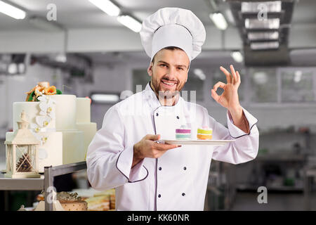 Le confiseur est en train de préparer un gâteau dans la cuisine de l'pastré Banque D'Images