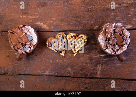 En forme de coeur belge gaufre avec du chocolat chaud avec de la guimauve sur fond de bois Banque D'Images