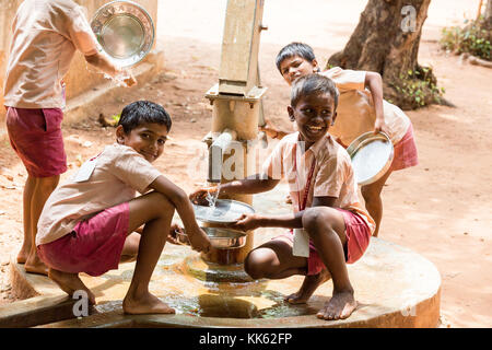 PONDICHERY, PUDUCHERY, INDE - 04 septembre, 2017. Enfants garçons filles non identifié nettoyer leurs assiettes après le déjeuner à la cantine en plein air. Banque D'Images