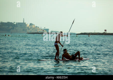 Couple sur un sup en face de la vieille ville de Jaffa, Tel Aviv, Israël Banque D'Images
