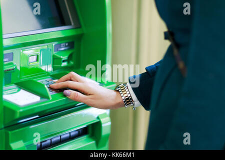 Photo de fille en robe verte au cash machine dans la chambre Banque D'Images