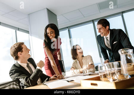 Groupe d'entreprises diverses personnes souriantes au cours d'une réunion en bureau. Heureux collègues rire dans une réunion dans la salle de conférence. Banque D'Images