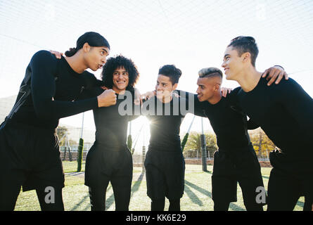 Jeune équipe sportive sur le terrain de football avant le match. joueurs de football discutant de stratégie et motivant et avant le match. Banque D'Images