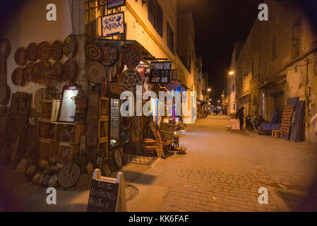 Magasins dans lumière du soir en alley à Essaouira, Maroc Banque D'Images